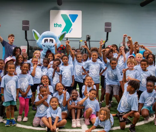 YMCA Day Campers pose with Manchester City players and mascot