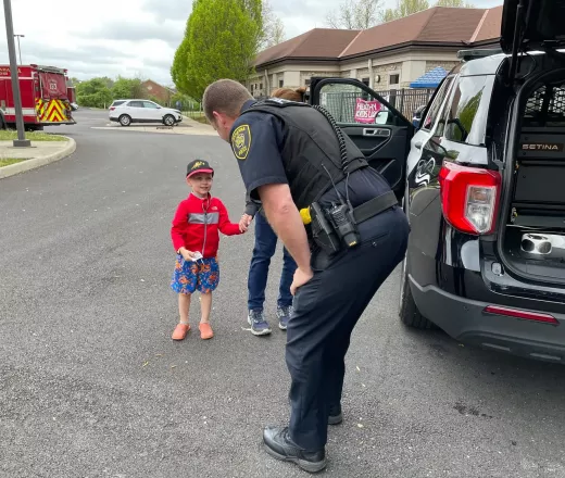 child at Gahanna YMCA greets police officer